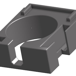 May include: A gray plastic holder with a circular opening, designed to hold a round object. The holder has a rectangular base and a raised lip around the opening.