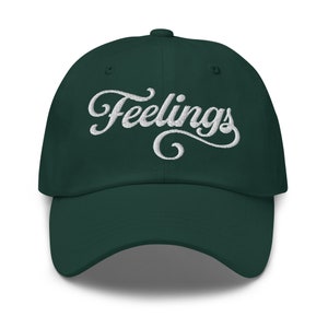 Op de afbeelding: Een donkergroene baseballpet met het woord "Feelings" in wit geborduurd op de voorkant.