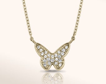 May include: A gold chain necklace with a small butterfly pendant encrusted with clear sparkling stones.