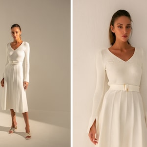 Milky white sweaterdress with V-neck and pleated skirt. Knitted warm winter dress in white color. Girl's sweaterdress A-Line