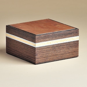 May include: A small wooden box with a dark brown finish and a thin silver and gold inlay around the top edge.