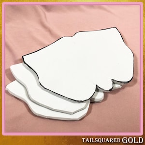 May include: A stack of three white, irregularly shaped cutouts with black edges, set against a pink background. The bottom right corner of the image has the text "TAILSQUARED GOLD".