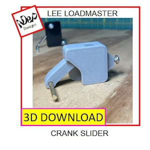 Può includere: Un cursore a manovella grigio stampato in 3D con un'asta in ottone e una vite argentata. L'immagine include il testo "LEE LOADMASTER", "3D DOWNLOAD" e "CRANK SLIDER". Un quadrato bordato di rosso con il logo "ADep Designs" è in alto a sinistra.