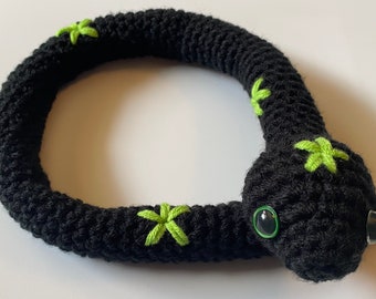 May include: Black crocheted snake toy with green star-shaped details and googly eyes.