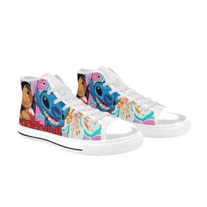 Op de afbeelding: Witte hoge canvas sneakers met een kleurrijke print met Stitch en Lilo uit de Disney-film Lilo & Stitch. De print bevat roze bloemen en de tekst "Lilo & Stitch".