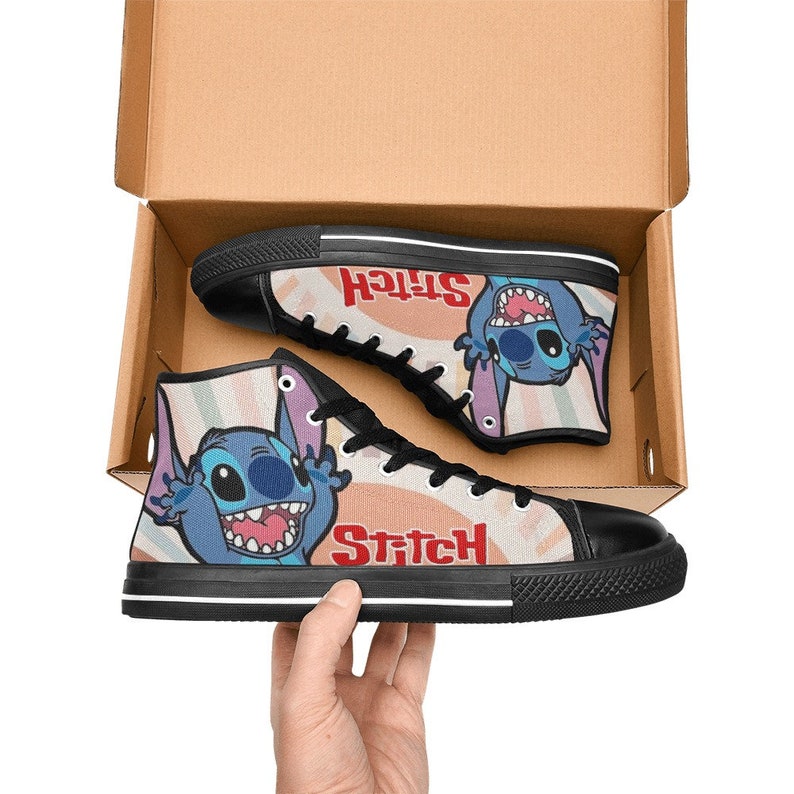 May include: A pair of black high-top canvas shoes with a colorful print featuring Stitch from Lilo & Stitch. The print includes the word "Stitch" in red letters.