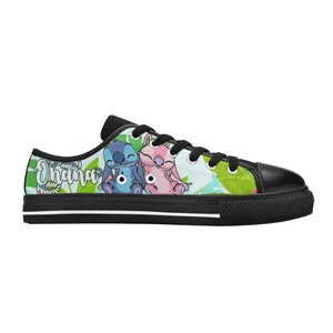 Puede incluir: Zapatillas bajas de lona negras con un dise&ntilde;o de dibujos animados verde, azul y rosa con Stitch y Angel de Lilo & Stitch. El texto "Ohana" est&aacute; impreso en el lateral de la zapatilla.