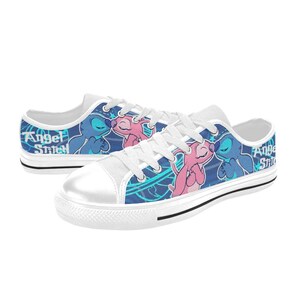 May include: White canvas low-top sneakers with a blue and teal background featuring a cartoon image of Stitch and Angel from the Disney movie Lilo & Stitch. The text "Angel Stitch" is printed on the side of the shoes.