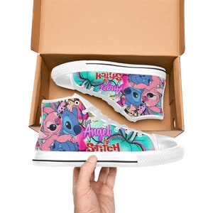 May include: White high-top canvas shoes with a colorful print featuring Stitch and Angel from the Disney movie Lilo & Stitch. The print includes the text "Angel & Stitch".