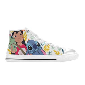 May include: White high-top sneakers featuring a colorful design of Lilo and Stitch characters. The shoes have a floral pattern background and a white rubber sole. The laces and eyelets are white.
