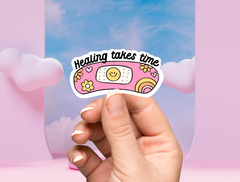 May include: A pink and yellow sticker with a cartoon bandage and the text "Healing takes time".