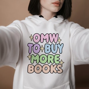 May include: White hoodie with a colourful graphic that says "OMW TO BUY MORE BOOKS".