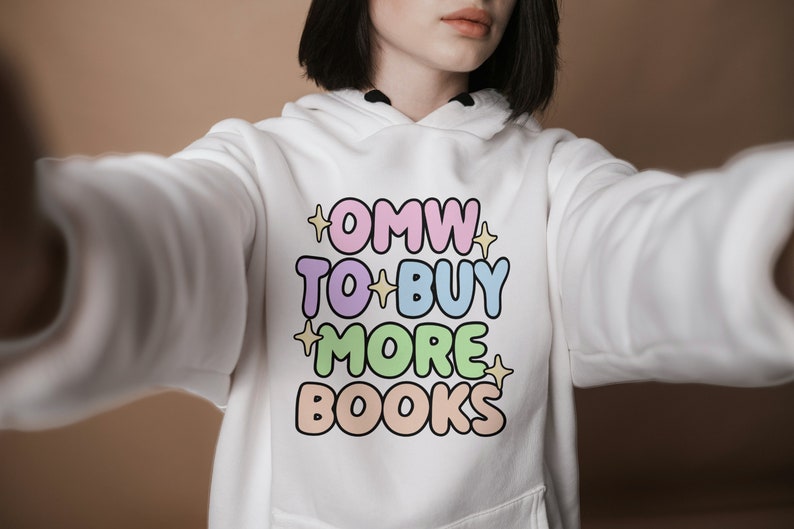 May include: White hoodie with a colourful graphic that says "OMW TO BUY MORE BOOKS".