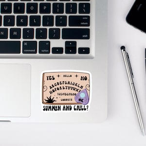 Pu&ograve; includere: Un adesivo di una tavola Ouija con il testo "SUMMON AND CHILL?" su un laptop.