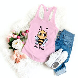 May include: A pink tank top with a cartoon bee graphic and the text "Bee Kind".