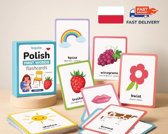 May include: A set of Polish first words flashcards in a blue box with a matching deck of cards. Each card features a colorful illustration, the Polish word, phonetic pronunciation, and English translation for items like a rainbow, grapes, and a cow.