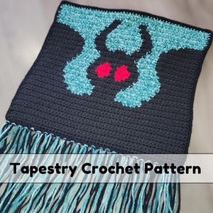 May include: A dark blue tapestry crochet pattern with a teal and black design and red accents. The design features a stylized moth. The bottom edge has teal and black fringe. The text "Tapestry Crochet Pattern" is across the bottom.