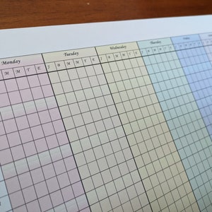 May include: A weekly planner with a grid layout. The days of the week are labeled: Monday, Tuesday, Wednesday, Thursday, Friday, and Saturday. The planner is color-coded with pink, yellow, light blue, and blue.