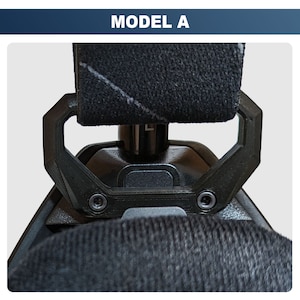 May include: Close-up of a black, adjustable, padded head strap with a metal buckle and a black plastic handle. The strap is designed for a helmet or headset.