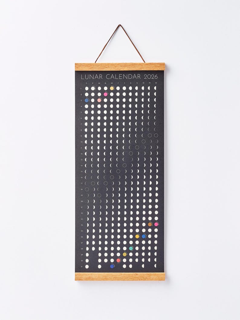 Moon Phase Lunar Calendar Print  hanging on wall with teak magnetic poster frame, modern minimalist home décor.
