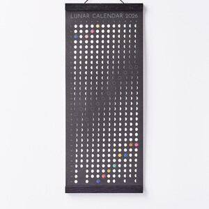 Moon Phase Lunar Calendar Print  hanging on wall with black magnetic poster frame, modern minimalist home décor.