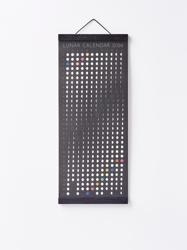 Moon Phase Lunar Calendar Print  hanging on wall with black magnetic poster frame, modern minimalist home décor.