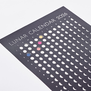 Close up of Moon Phase Lunar Calendar Print -, black and white wall art showing all lunar phases. Colourful full moons with names and timings