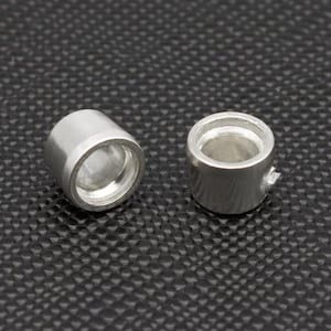 May include: Two silver metal rings with a smooth, polished finish. The rings are cylindrical in shape and have a slightly bevelled edge.