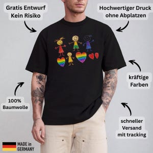 May include: Black t-shirt with a colorful crayon drawing of stick figures and rainbow hearts. The shirt is made of 100% cotton and features the text "MADE IN GERMANY".