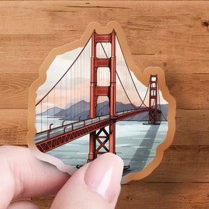 May include: A sticker featuring a red and orange illustration of the Golden Gate Bridge in San Francisco, California.