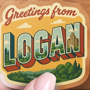 May include: A sticker with a vintage postcard design that says "Greetings from Logan." The word "Logan" is in large, 3D block letters with a landscape scene inside each letter. The sticker is held by a hand.