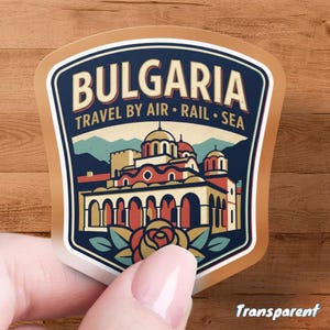 May include: A sticker with a tan border and a blue and tan design. The sticker says "BULGARIA" at the top, with "TRAVEL BY AIR • RAIL • SEA" below. The design features a building with red domes and a rose.