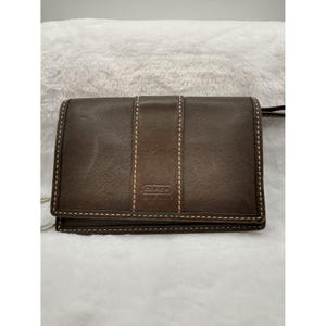 Cartera de mujer de piel marrón con cierre a presión y llavero de Coach