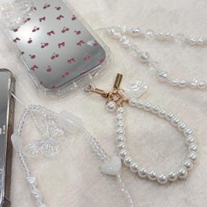 Ciondolo per telefono a forma di cuore con conchiglia, perla e fiocco a forma di stella bianca, fatto a mano, custodia per telefono kawaii, cordino da polso per telefono, regalo per lei