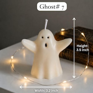 K&ouml;nnte beinhalten: Eine cremewei&szlig;e, geisterf&ouml;rmige Kerze mit wei&szlig;em Docht, zwei schwarzen Augen und einem offenen Mund. Die Kerze ist mit Ghost# 7 beschriftet, 8,89 cm hoch und 8,13 cm breit und von einer d&uuml;nnen Lichterkette mit kleinen LED-Leuchten umgeben.