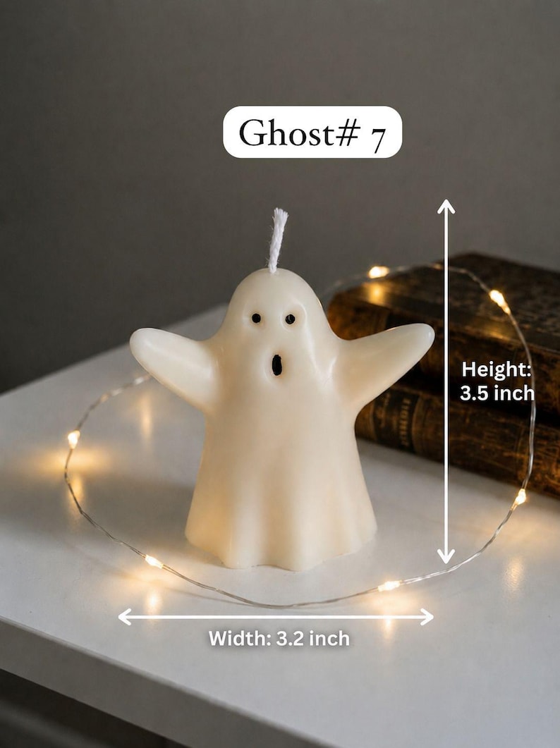 K&ouml;nnte beinhalten: Eine cremewei&szlig;e, geisterf&ouml;rmige Kerze mit wei&szlig;em Docht, zwei schwarzen Augen und einem offenen Mund. Die Kerze ist mit Ghost# 7 beschriftet, 8,89 cm hoch und 8,13 cm breit und von einer d&uuml;nnen Lichterkette mit kleinen LED-Leuchten umgeben.