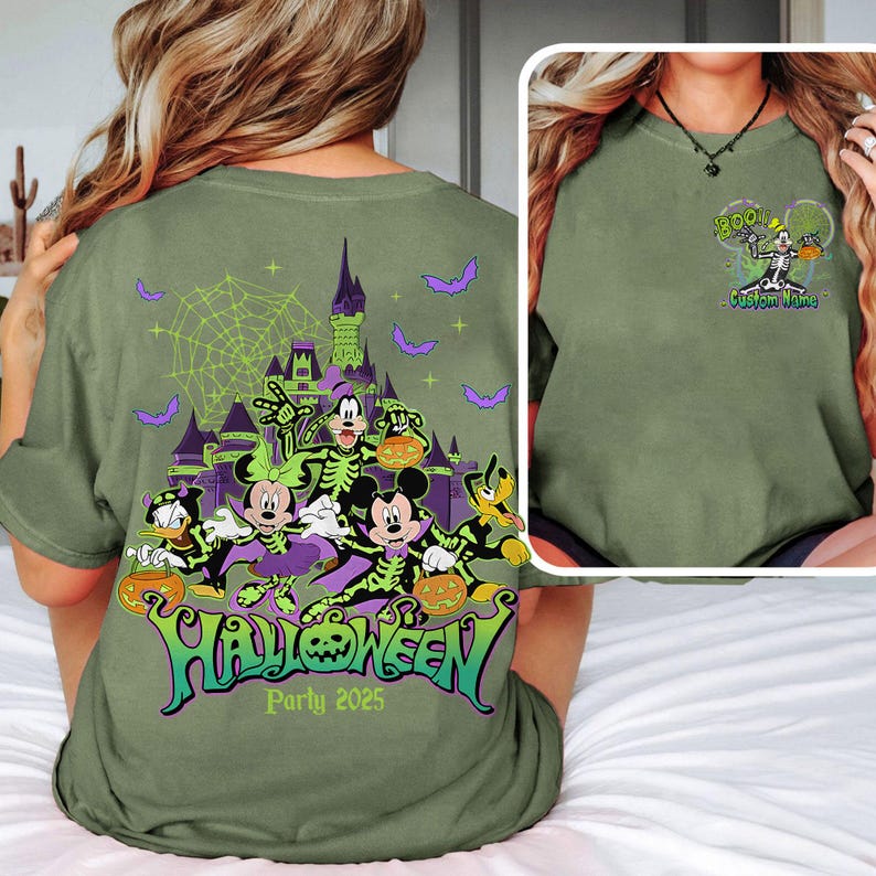 Op de afbeelding: Olijfgroen Halloween Party 2025 t-shirt met een griezelig ontwerp met stripfiguren, een spookkasteel, vleermuizen en het woord "Halloween" in groen en paars. De voorkant van de shirt heeft een skelet karakter met het woord "BOO!" en "Custom Name".