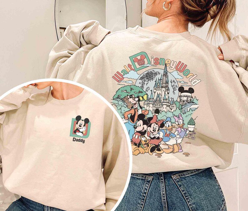 Puede incluir: Sudadera beige con un gr&aacute;fico de Mickey Mouse en la parte delantera y un dise&ntilde;o de Walt Disney World en la parte trasera. El gr&aacute;fico frontal incluye la palabra "Daddy". El dise&ntilde;o trasero muestra personajes de Disney y un castillo.