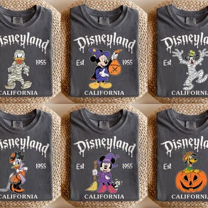 May include: Six dark gray t-shirts with Halloween-themed Disneyland graphics. Each shirt features a different Disney character dressed in a Halloween costume, with the Disneyland logo and "Est 1955 California" printed on the front.