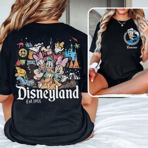 May include: Black t-shirts with Disney character designs. One shirt displays a Disneyland graphic with Mickey, Minnie, Donald, Daisy, Goofy, and Pluto. The other features Donald Duck and the word "Brother".