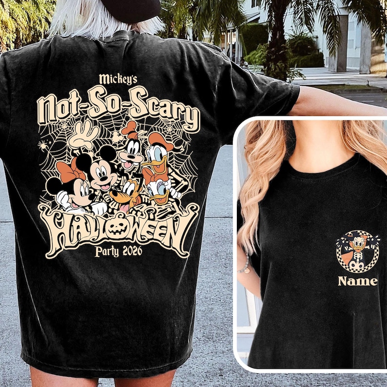 May include: Black t-shirt featuring a Halloween design with Mickey Mouse, Minnie Mouse, Donald Duck, and Goofy. The text reads "Mickey's Not-So-Scary Halloween Party 2026." A smaller image of Donald Duck in a Halloween costume is on the front.