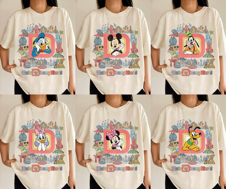 May include: Cream-colored t-shirts featuring various Disney characters inside a red-outlined letter "D" with "Walt Disney World" text. Characters include Donald Duck, Mickey Mouse, Goofy, Daisy Duck, Minnie Mouse, and Pluto. The shirts have a vintage, cartoon style.