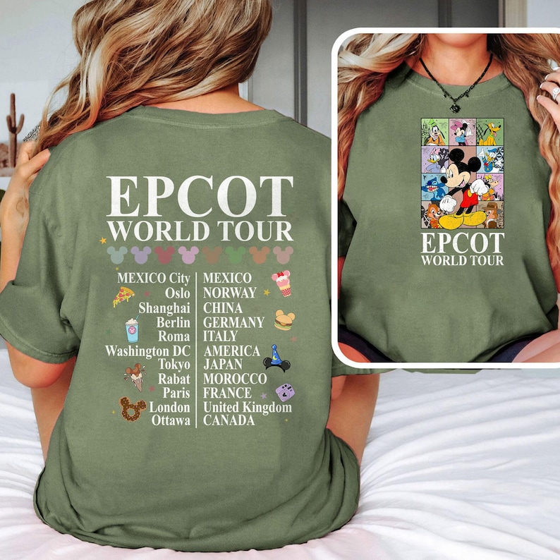 Pode incluir: Camiseta verde com o texto "EPCOT WORLD TOUR" e uma lista de cidades e pa&iacute;ses. A parte de tr&aacute;s da camiseta apresenta uma ilustra&ccedil;&atilde;o colorida do Mickey Mouse e outros personagens da Disney com o texto "EPCOT WORLD TOUR".
