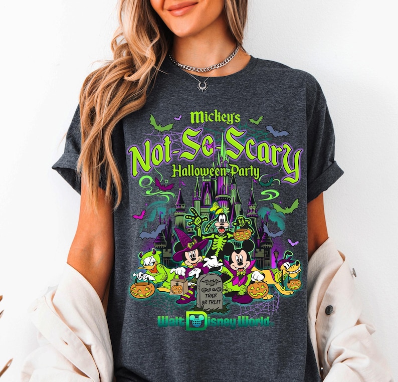 May include: Dark grey t-shirt with a Halloween-themed design. The shirt displays the text "Mickey's Not-So-Scary Halloween Party" in green and purple. The graphic includes cartoon characters, a castle, bats, and pumpkins. The Walt Disney World logo is at the bottom.