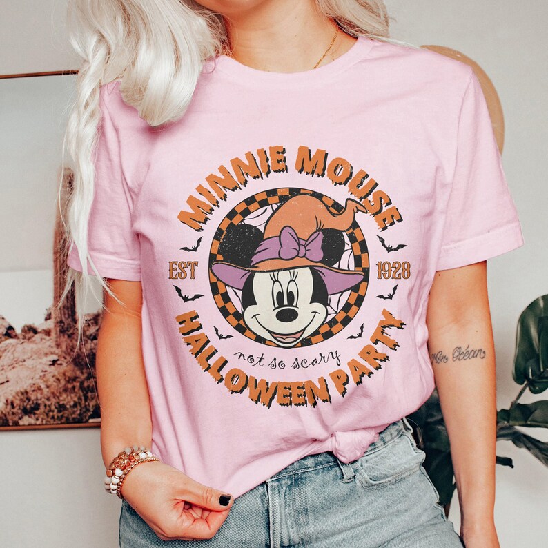 K&ouml;nnte beinhalten: Pinkes T-Shirt mit einem Vintage-Grafikdruck von Minnie Mouse als Hexe. Der Aufdruck lautet "Minnie Mouse Est 1928 Halloween Party - not so scary".