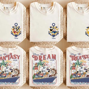May include: Cream-colored t-shirts with Disney character designs. Some shirts feature Mickey Mouse, Donald Duck, and Pluto in anchors. Other shirts have a cruise ship design with the words "Fantasy," "Dream," and "Treasure" and the year 2026.