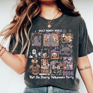 May include: Dark gray t-shirt featuring a Halloween-themed design with the text "WALT DISNEY WORLD" and "MICKEY'S Not-So-Scary Halloween Party 2026". The design includes cartoon characters and Halloween imagery.