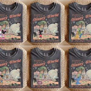 May include: Six dark gray t-shirts with a vintage-style Disney World graphic. Each shirt features a different Disney character, including Mickey, Minnie, Goofy, and Stitch, with the text "Florida Disney World" and "The Most Magical Place on Earth."
