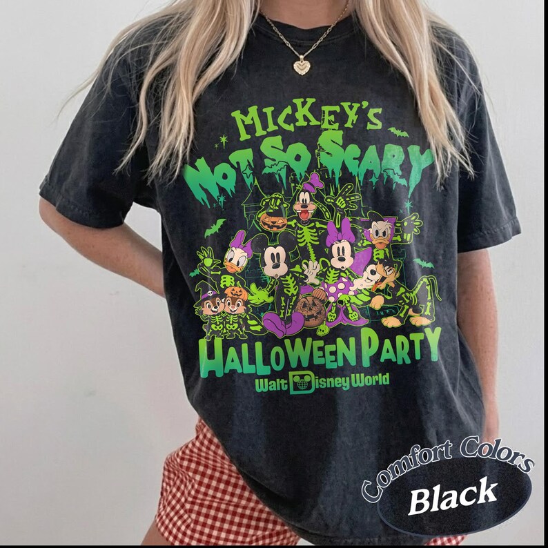 Op de afbeelding: Zwart Comfort Colors T-shirt met een Halloween-afbeelding. Het ontwerp toont Disney-personages en de tekst "Mickey's Not So Scary Halloween Party".
