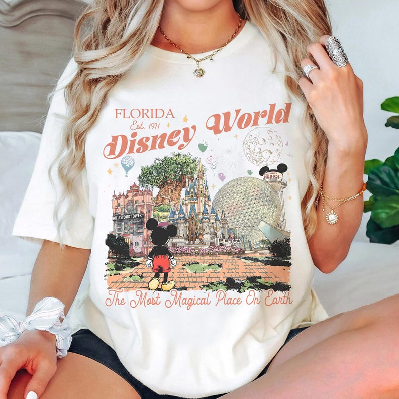 May include: A white ceramic mug with a black handle and the text "But first, coffee" in a black, handwritten-style font. The mug is on a white surface.